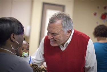 Georgia Gov.-elect Nathan Deal, right, meets Cynthia McDaniel, left, and her son Devon Scott, 6 months, while visiting the Atlanta Mission homeless shelter for women to kick off inaugural festivities  in Atlanta. (AP Photo/David Goldman)